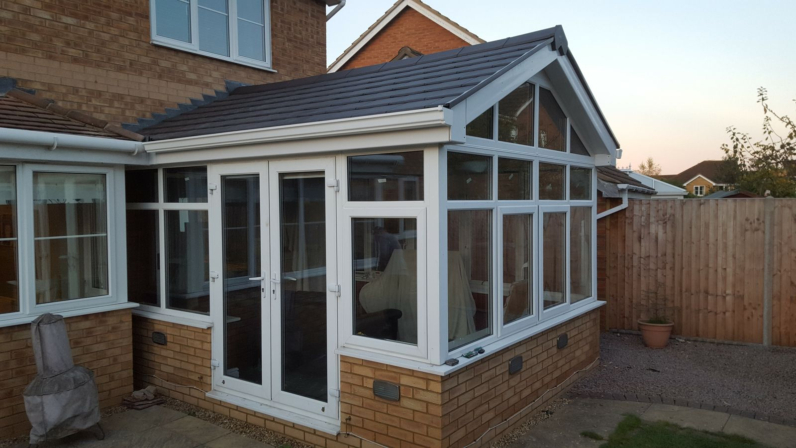Solid roof conservatory with tiled roof and white uPVC frames